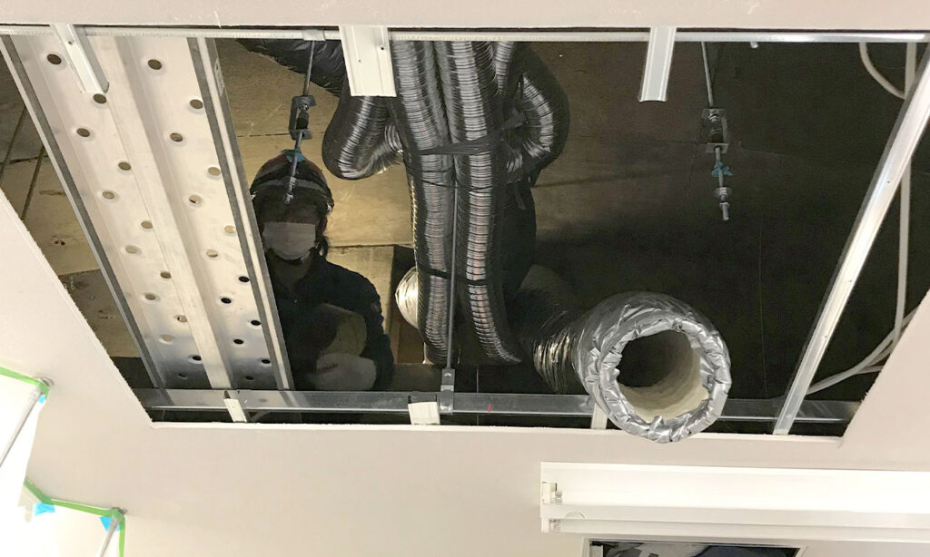 天井を開口して、天井裏でダクトを繋ぎ、高機能換気設備の設置作業を行います。